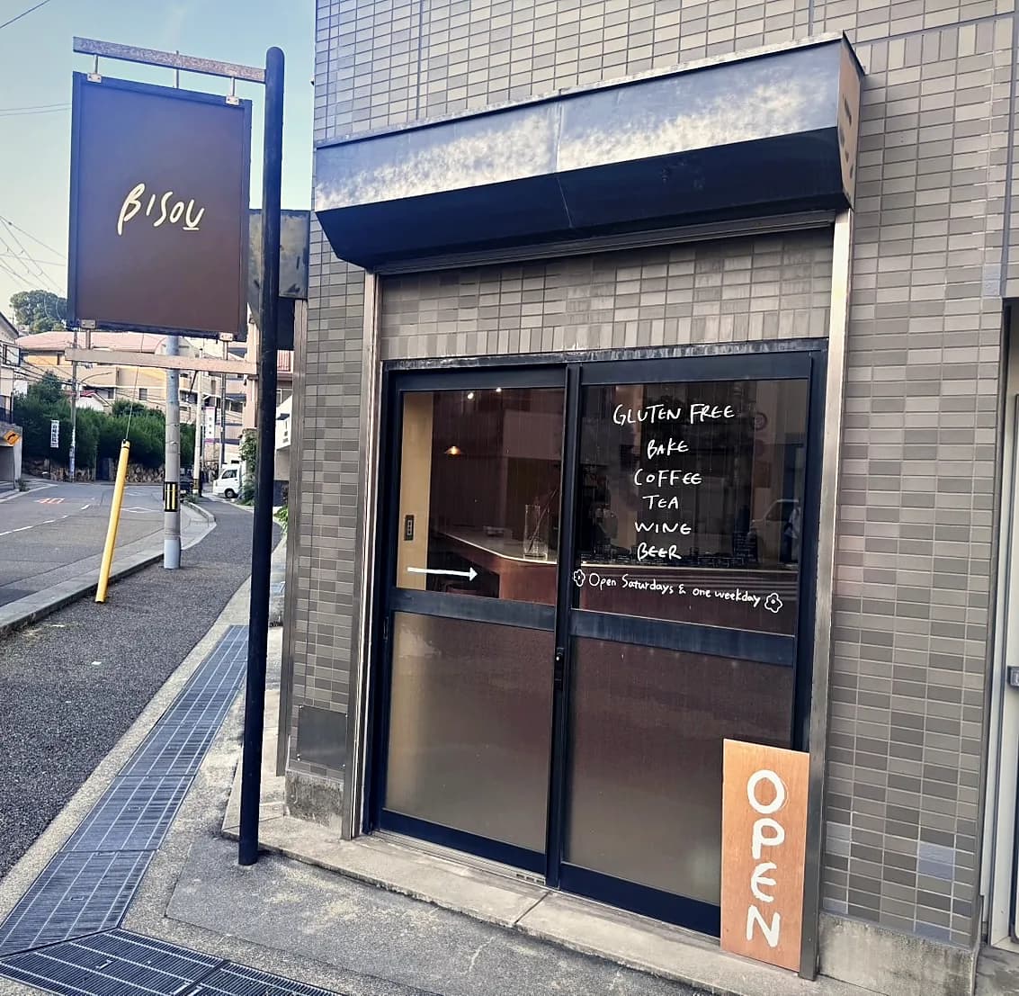 看板と手書きのガラス扉が迎えるBISOUの店先